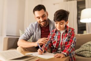 Young male student working on homework with father