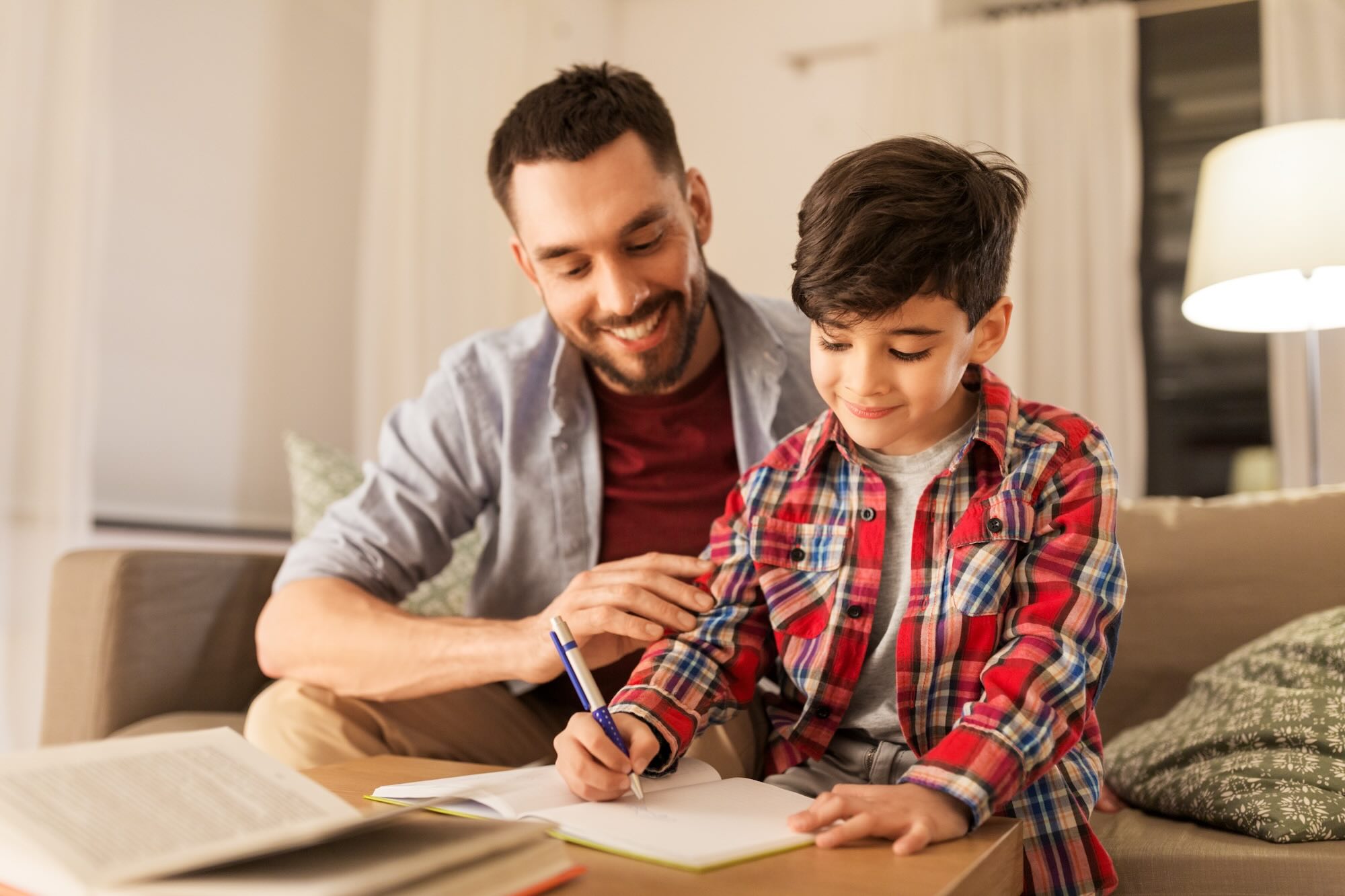 Young male student working on homework with father