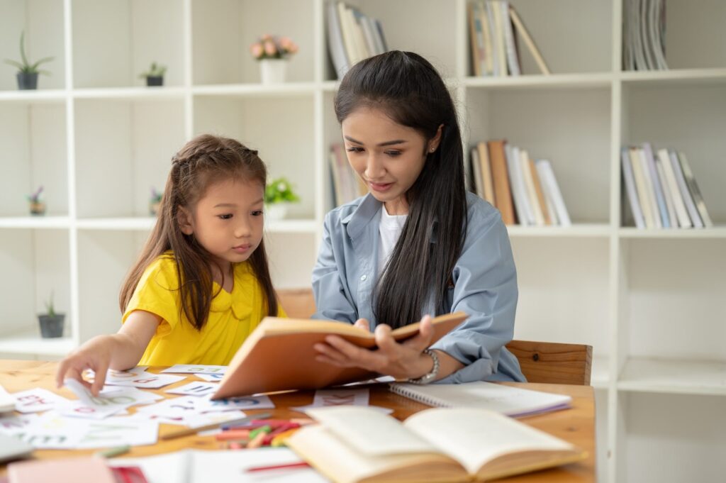 Little girl working on homework with mother