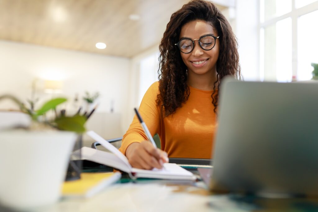 Woman smiling and writing down in journal