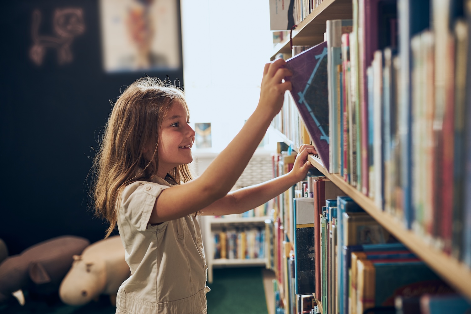 Child pulling book off of the shelf