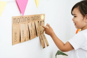 Young child completing a chore chart while balancing online school.