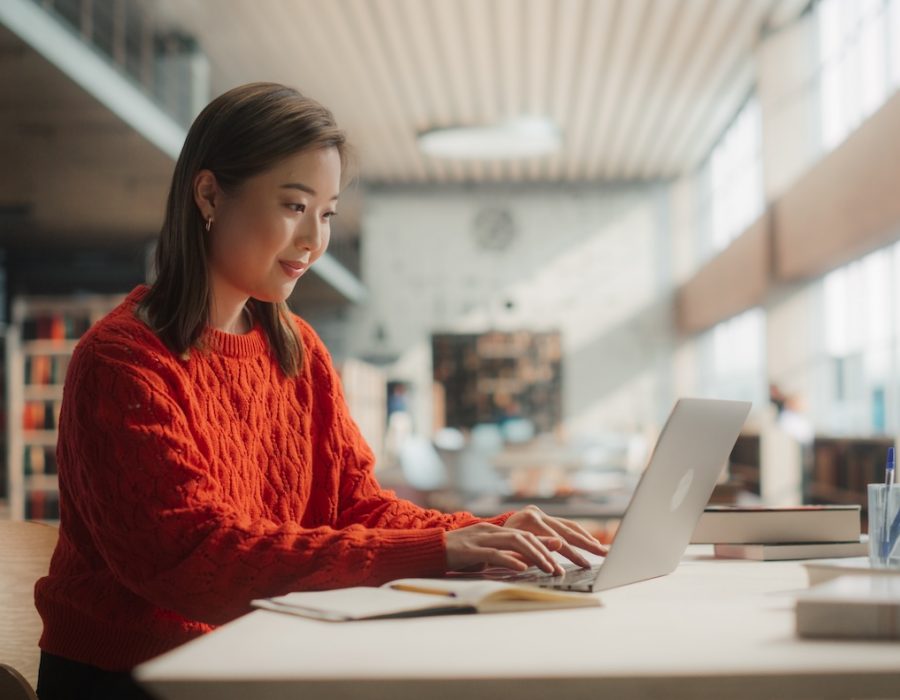 Asian student smiling at computer